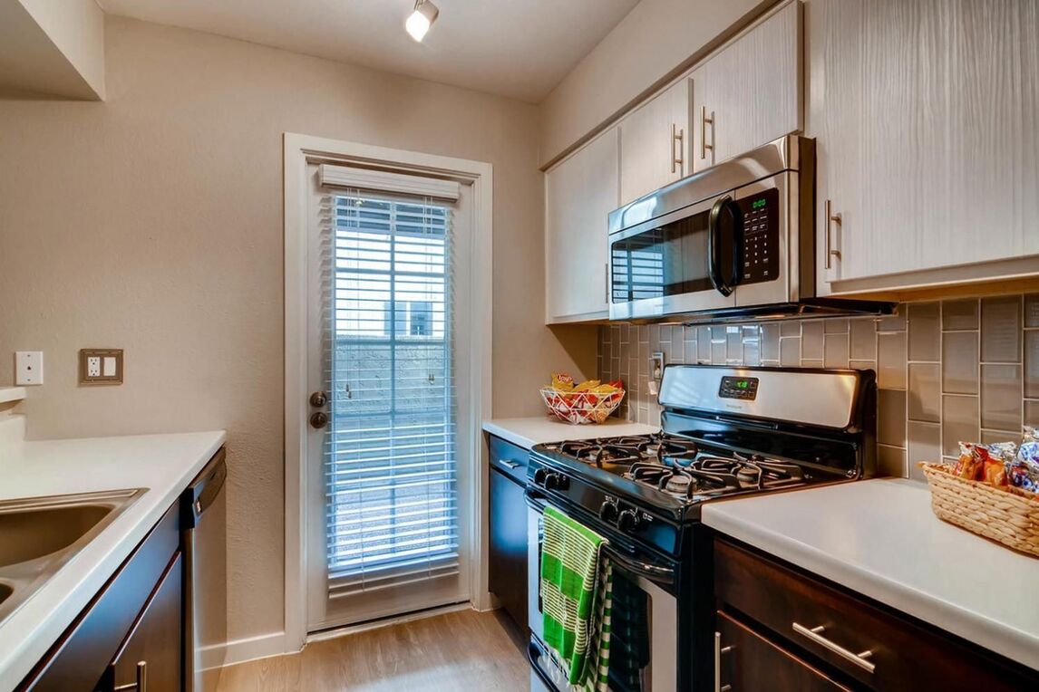 View of kitchen with gas stove and kitchen exit door