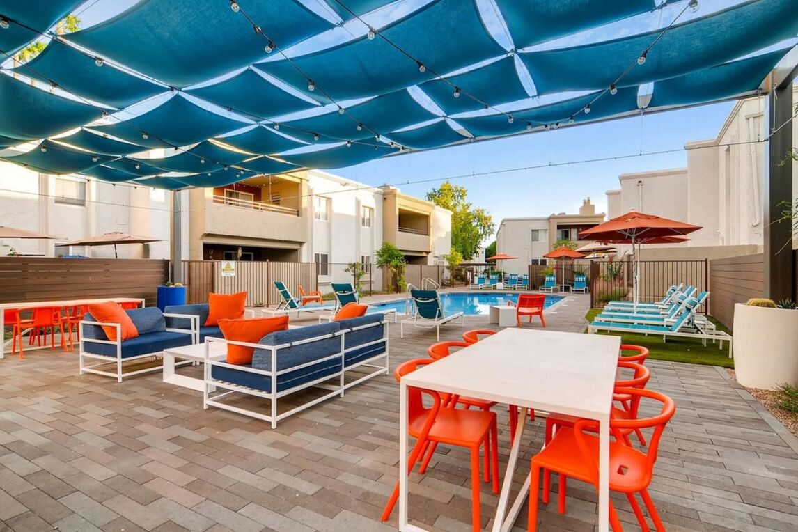 covered seating and grill area by the pool