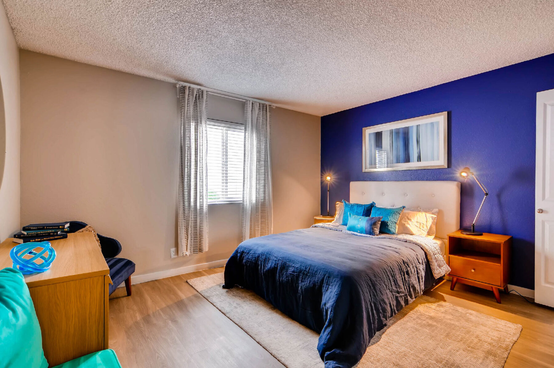 Bedroom with blue accent wall and large window